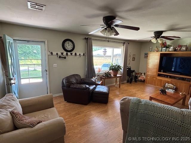 902 NE Rushwood Dr, Stigler, OK 74462 - living room featuring a ceiling fan, plenty of natural light, and wood finished floors