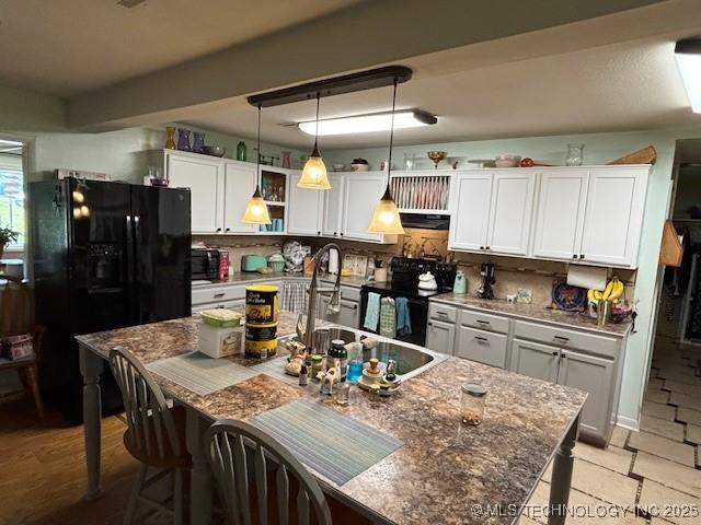 902 NE Rushwood Dr, Stigler, OK 74462 - kitchen with black appliances, tasteful backsplash, pendant lighting, and white cabinets