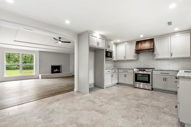 10062 E Northshire St, Claremore, OK 74017 - kitchen with stainless steel range oven, custom range hood, built in microwave, a ceiling fan, and tasteful backsplash