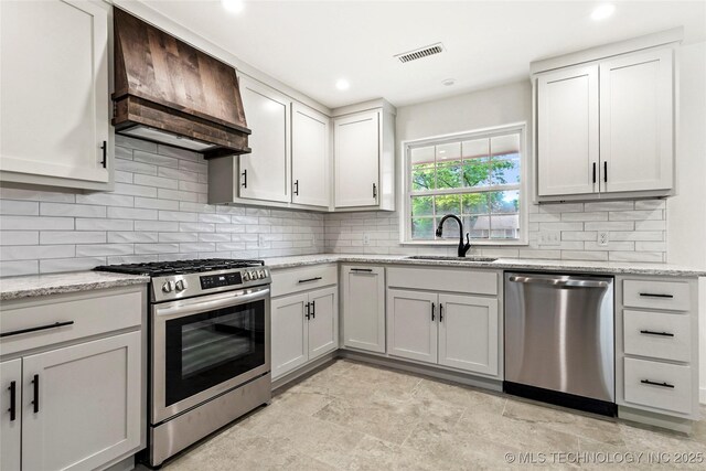 10062 E Northshire St, Claremore, OK 74017 - kitchen featuring appliances with stainless steel finishes, premium range hood, tasteful backsplash, light stone counters, and recessed lighting