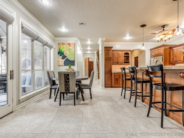 9025 N 100th E Ave, Owasso, OK 74055 - dining space featuring arched walkways, ornamental molding, ceiling fan, and light tile patterned floors