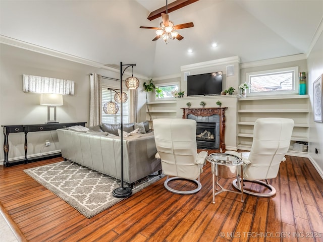 9025 N 100th E Ave, Owasso, OK 74055 - living area with ceiling fan, a glass covered fireplace, wood finished floors, high vaulted ceiling, and beam ceiling