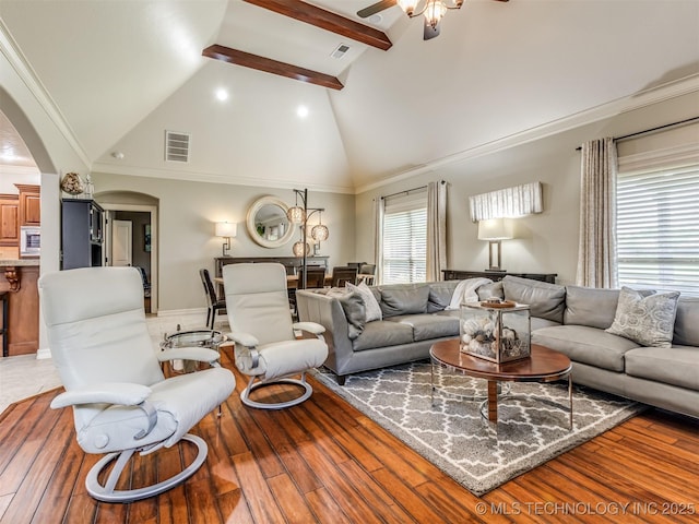 9025 N 100th E Ave, Owasso, OK 74055 - living area with arched walkways, a ceiling fan, high vaulted ceiling, beam ceiling, and wood finished floors