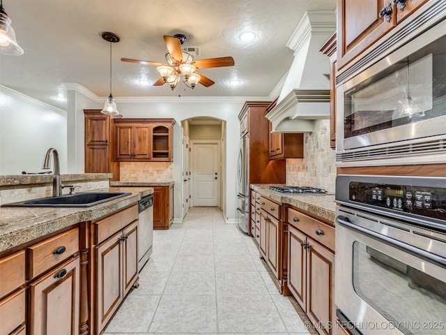 9025 N 100th E Ave, Owasso, OK 74055 - kitchen with appliances with stainless steel finishes, tile countertops, brown cabinets, backsplash, and a ceiling fan