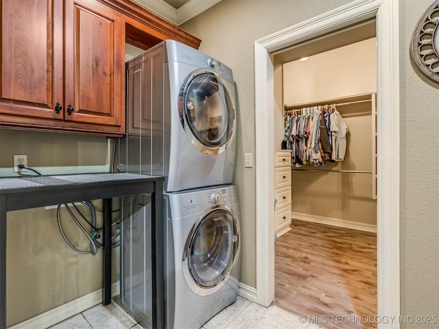 9025 N 100th E Ave, Owasso, OK 74055 - washroom with stacked washer / dryer, cabinet space, light wood-style flooring, and crown molding