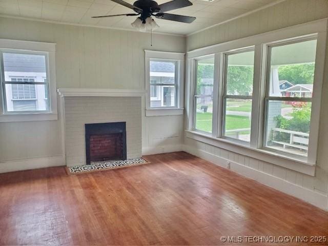 1319 Bixby St, Ardmore, OK 73401 - unfurnished living room with ceiling fan, plenty of natural light, wood finished floors, a fireplace, and ornamental molding