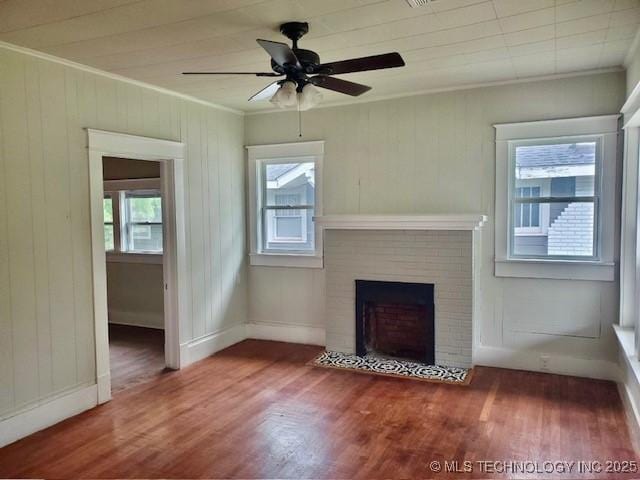 1319 Bixby St, Ardmore, OK 73401 - unfurnished living room with crown molding, healthy amount of natural light, wood finished floors, ceiling fan, and a brick fireplace