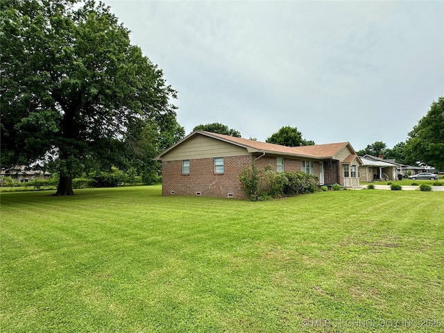 705 W 3rd St, Skiatook, OK 74070 - view of property exterior featuring brick siding, a yard, and crawl space