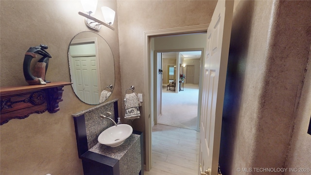 3302 Callaway Dr, Claremore, OK 74019 - bathroom featuring wood finished floors, vanity, and a textured wall