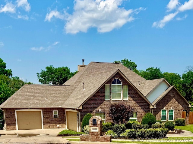 3302 Callaway Dr, Claremore, OK 74019 - view of front facade with an attached garage, concrete driveway, brick siding, a shingled roof, and a chimney