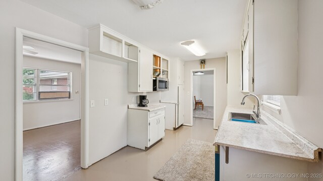4944 Cornell Dr, Bartlesville, OK 74006 - kitchen with light countertops, white cabinetry, and stainless steel microwave