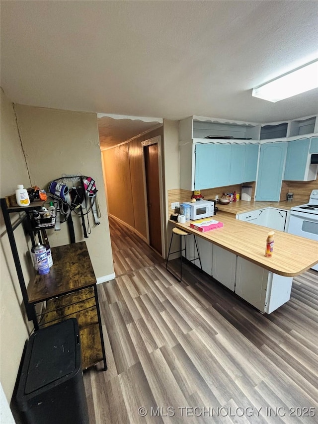 1503 Hillcrest, Durant, OK 74701 - kitchen featuring white appliances, wood finished floors, and a peninsula