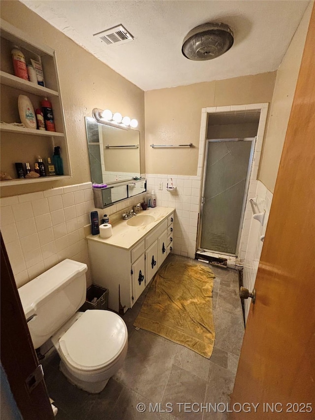 1503 Hillcrest, Durant, OK 74701 - bathroom with tile walls, a stall shower, built in features, vanity, and a wainscoted wall