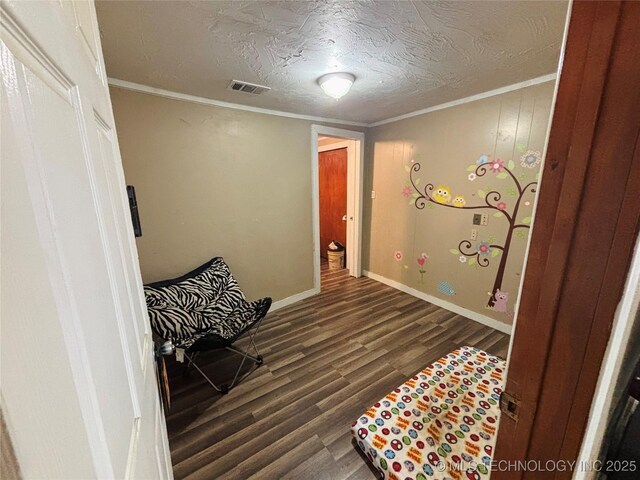 1503 Hillcrest, Durant, OK 74701 - sitting room with wood finished floors, ornamental molding, and a textured ceiling