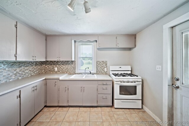 525 S 3rd Ave, Hallett, OK 74034 - kitchen with white gas range oven, tasteful backsplash, light countertops, and light tile patterned floors