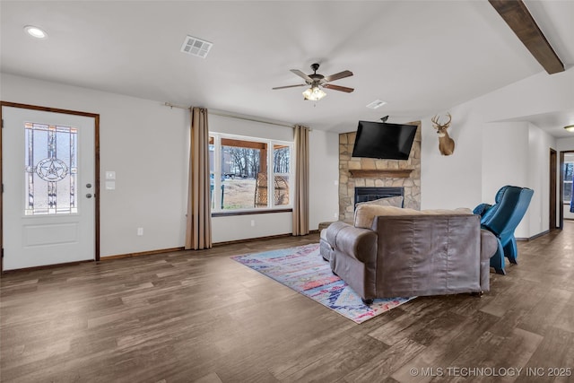 6335 S Watson, Sulphur, OK 73086 - living area with healthy amount of natural light, wood finished floors, a stone fireplace, beamed ceiling, and recessed lighting