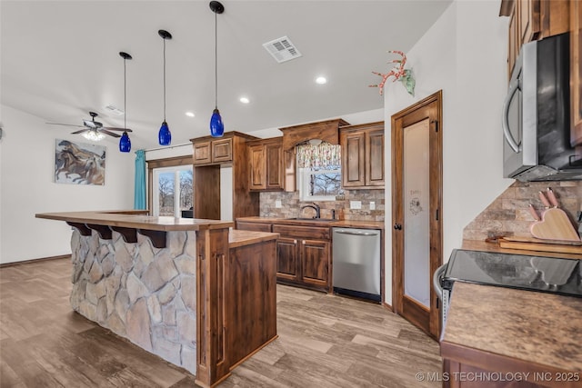 6335 S Watson, Sulphur, OK 73086 - kitchen with appliances with stainless steel finishes, light wood finished floors, tasteful backsplash, plenty of natural light, and recessed lighting