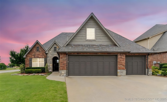 113 E 128th St S, Jenks, OK 74037 - view of front of house with a garage, driveway, a front lawn, stone siding, and brick siding