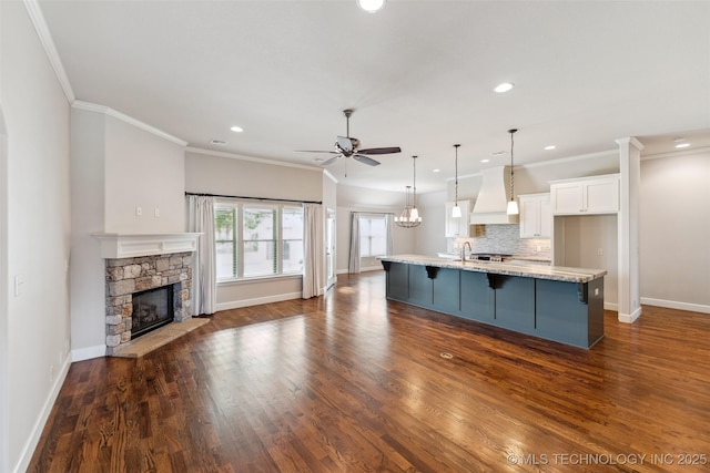 113 E 128th St S, Jenks, OK 74037 - kitchen featuring custom range hood, ceiling fan, white cabinetry, a kitchen breakfast bar, and recessed lighting