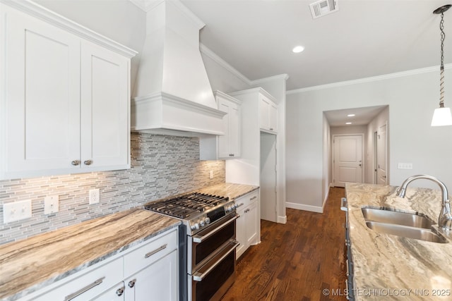 113 E 128th St S, Jenks, OK 74037 - kitchen with range with two ovens, wall chimney exhaust hood, white cabinets, light stone counters, and crown molding