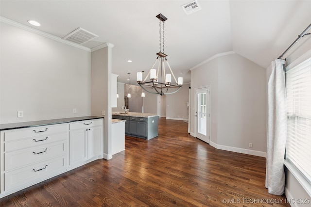 113 E 128th St S, Jenks, OK 74037 - kitchen featuring a chandelier, dark wood-style floors, pendant lighting, ornamental molding, and a peninsula