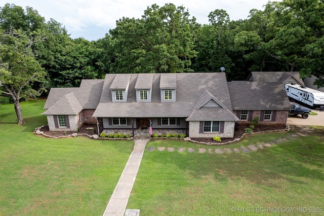 209 Shell Ln, Durant, OK 74701 - view of front of house with a front lawn, stone siding, and roof with shingles