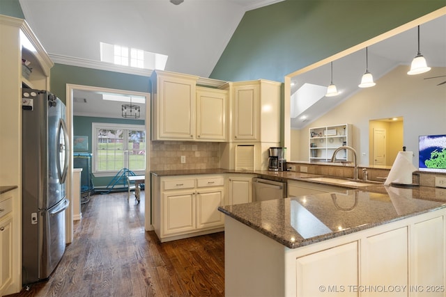 209 Shell Ln, Durant, OK 74701 - kitchen with stainless steel appliances, vaulted ceiling, cream cabinets, crown molding, and dark wood-style floors