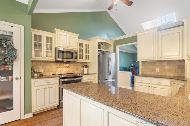 209 Shell Ln, Durant, OK 74701 - kitchen featuring appliances with stainless steel finishes, a ceiling fan, stone countertops, decorative backsplash, and lofted ceiling