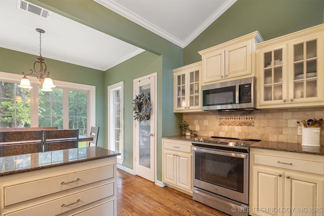 209 Shell Ln, Durant, OK 74701 - kitchen with appliances with stainless steel finishes, cream cabinets, light wood-style flooring, decorative backsplash, and ornamental molding