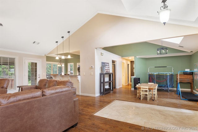 209 Shell Ln, Durant, OK 74701 - living room featuring wood finished floors, ornamental molding, a chandelier, and high vaulted ceiling