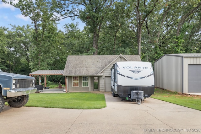 209 Shell Ln, Durant, OK 74701 - view of front of home with a front lawn, an outdoor structure, and a shingled roof