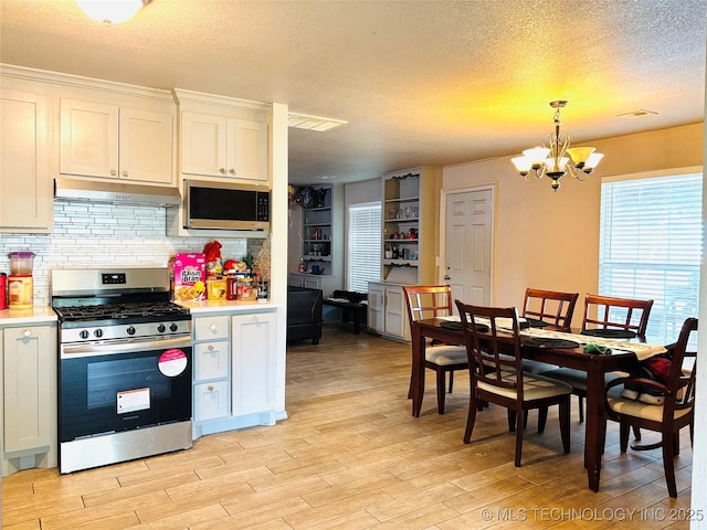 7936 S 72nd E Ave, Tulsa, OK 74133 - kitchen with stainless steel appliances, under cabinet range hood, light wood-style flooring, a chandelier, and a textured ceiling