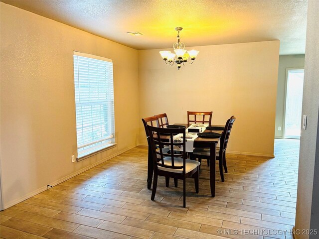 7936 S 72nd E Ave, Tulsa, OK 74133 - dining area with a chandelier, wood finished floors, and a textured ceiling