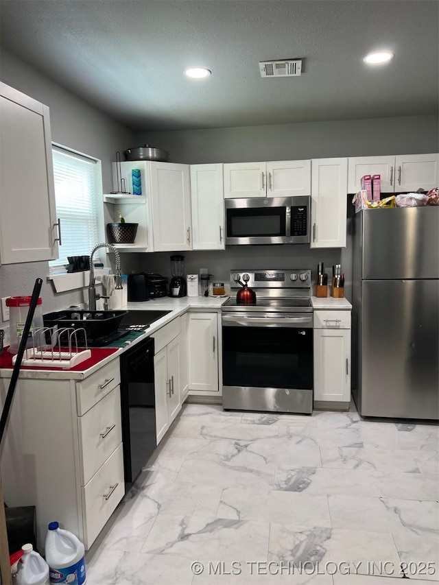 329 E Zion Pl, Tulsa, OK 74106 - kitchen featuring stainless steel appliances, white cabinetry, recessed lighting, light countertops, and light marble finish flooring