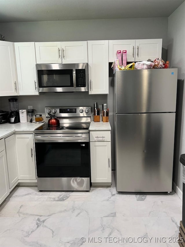 329 E Zion Pl, Tulsa, OK 74106 - kitchen featuring appliances with stainless steel finishes, light marble finish floors, light countertops, and white cabinets