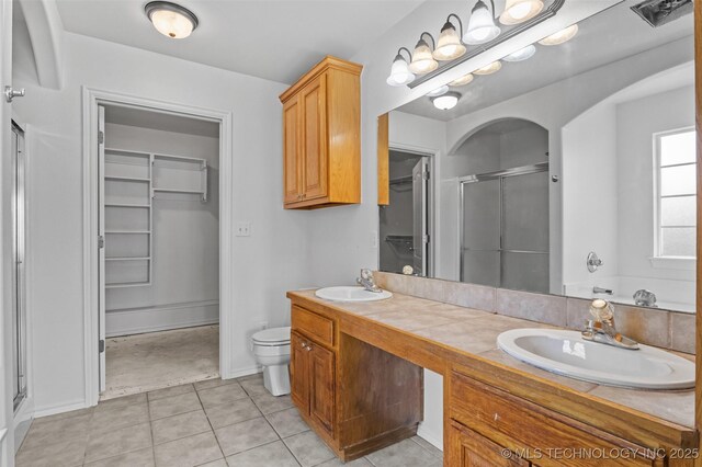 13124 N 133rd E Ave, Collinsville, OK 74021 - bathroom with a shower stall, double vanity, a walk in closet, and tile patterned floors