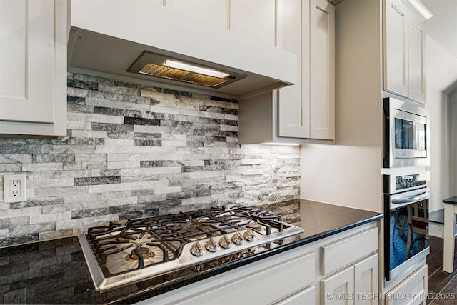 30109 Gale Ave, Inola, OK 74036 - kitchen with extractor fan, stainless steel appliances, backsplash, dark countertops, and white cabinetry