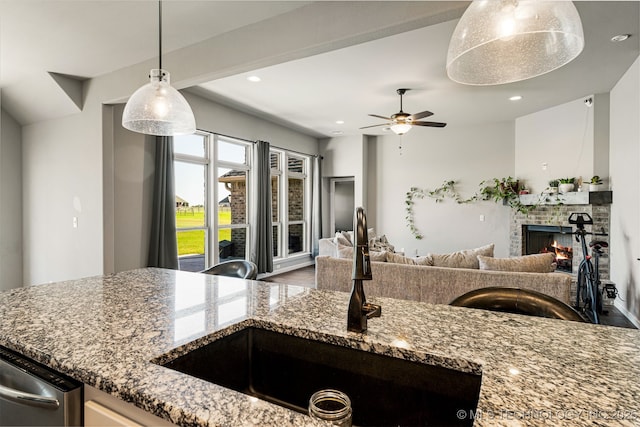 30109 Gale Ave, Inola, OK 74036 - kitchen featuring open floor plan, stone counters, a brick fireplace, hanging light fixtures, and dishwasher