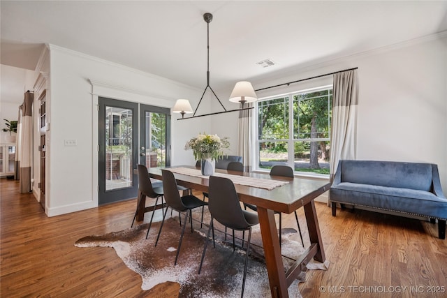 1617 S St Louis Ave, Tulsa, OK 74120 - dining room with wood finished floors, ornamental molding, healthy amount of natural light, and a chandelier