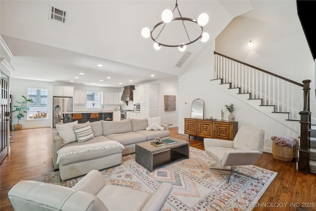 1617 S St Louis Ave, Tulsa, OK 74120 - living room with wood finished floors, high vaulted ceiling, a chandelier, stairway, and recessed lighting