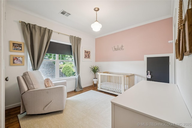 1617 S St Louis Ave, Tulsa, OK 74120 - bedroom with wood finished floors, crown molding, and a crib