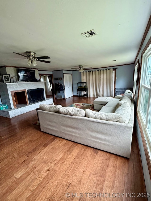 416 E 7th St, Dewey, OK 74029 - living area with ceiling fan, wood finished floors, and a fireplace with raised hearth