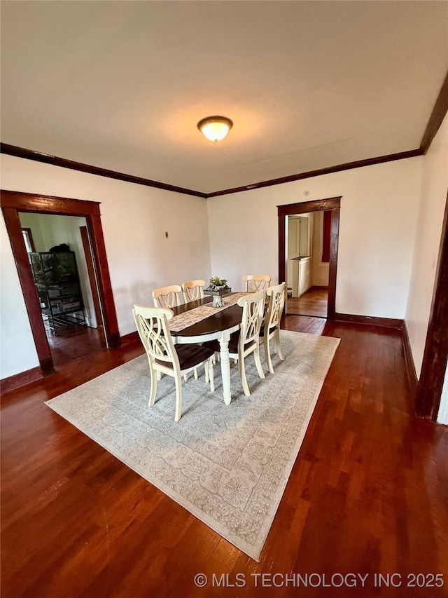 416 E 7th St, Dewey, OK 74029 - dining space featuring crown molding and dark wood-type flooring