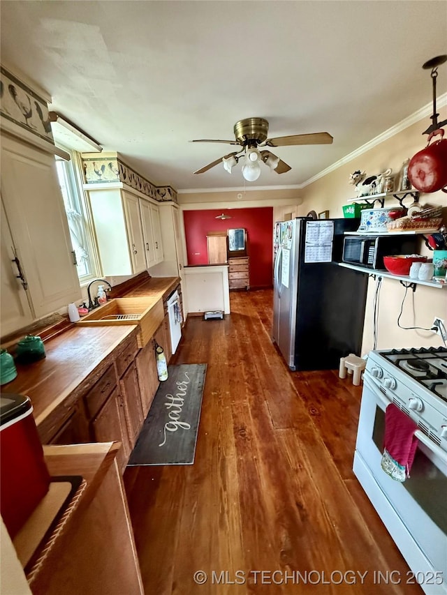 416 E 7th St, Dewey, OK 74029 - kitchen with white gas range oven, freestanding refrigerator, black microwave, ceiling fan, and dark wood-style floors