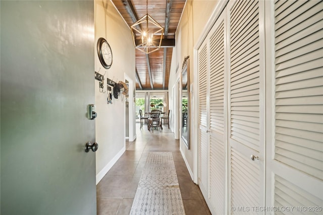 2536 E 57th St, Tulsa, OK 74105 - hallway with a wood ceiling with exposed beams, tile patterned floors, a towering ceiling, and a chandelier