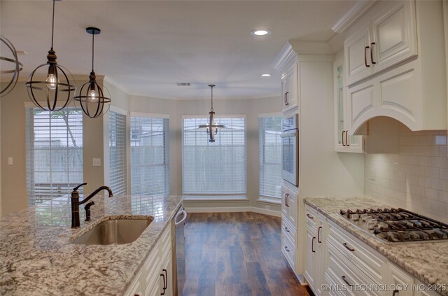 5512 S Columbia Ct, Tulsa, OK 74105 - kitchen with appliances with stainless steel finishes, a chandelier, dark wood-style floors, white cabinets, and backsplash