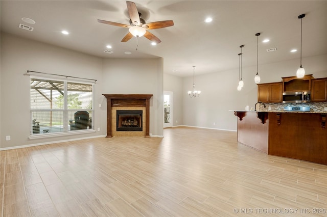 1908 E 133rd Ct, Bixby, OK 74008 - unfurnished living room featuring a ceiling fan, healthy amount of natural light, a chandelier, a fireplace, and recessed lighting