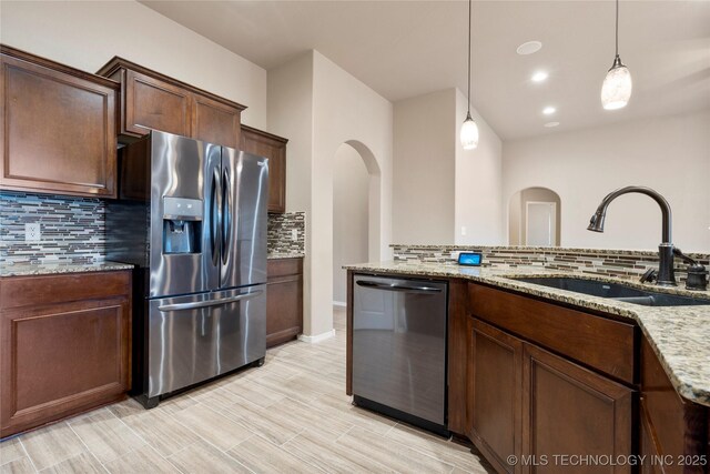 1908 E 133rd Ct, Bixby, OK 74008 - kitchen with appliances with stainless steel finishes, decorative backsplash, pendant lighting, light stone countertops, and recessed lighting