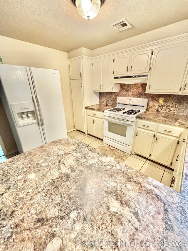 106 E Elk Rd, Whitefield, OK 74472 - kitchen featuring white appliances, under cabinet range hood, light tile patterned flooring, tasteful backsplash, and a textured ceiling