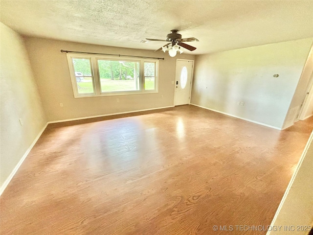 106 E Elk Rd, Whitefield, OK 74472 - spare room featuring a textured ceiling, a ceiling fan, and wood finished floors